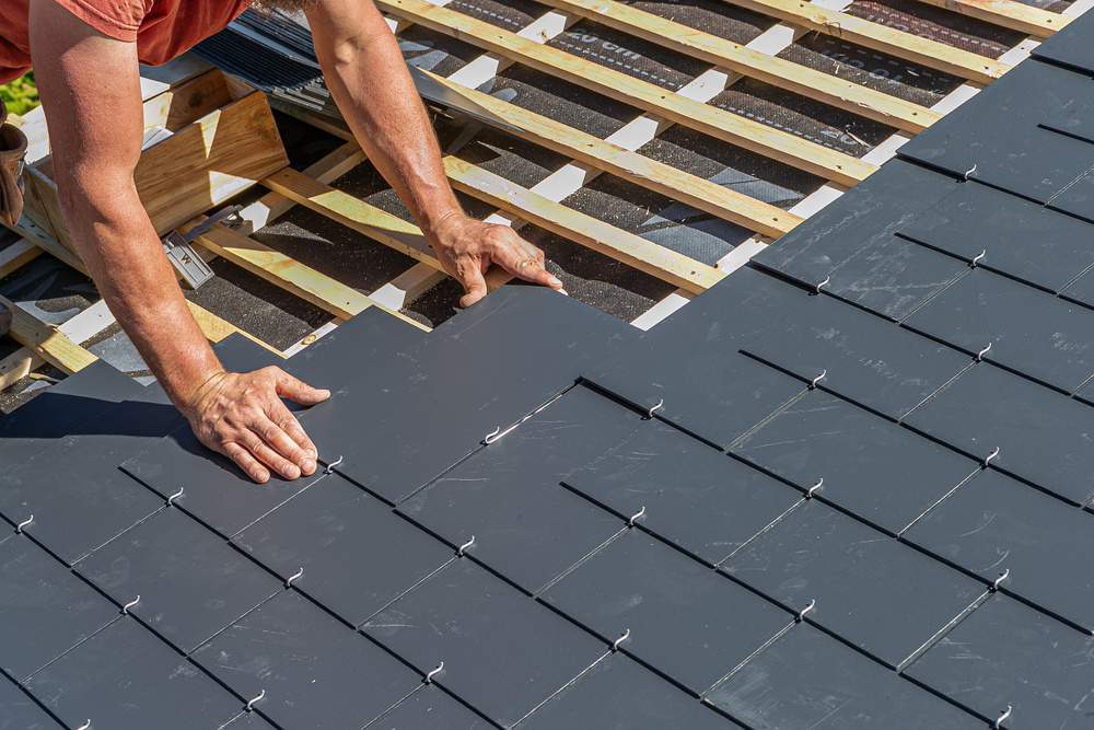 Men installing a slate roof home professional-roof-workers repairing roof working on rooftop